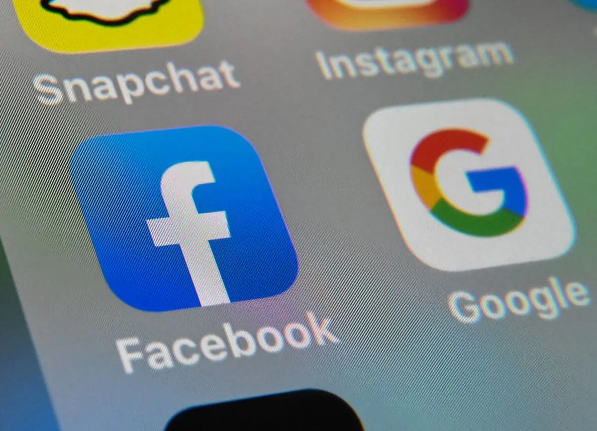 The logos of mobile apps Facebook and Google displayed on a tablet in this file photo. (Denis Charlet/AFP via Getty Images)