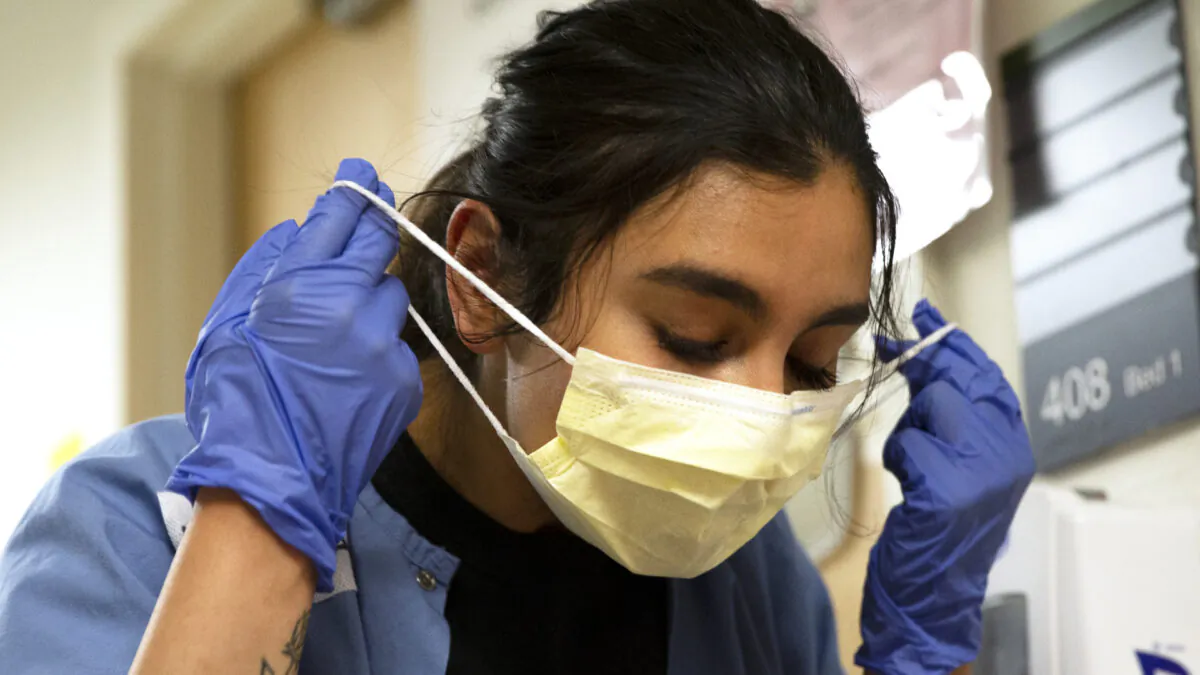 A nurse carefully removes her mask and PPE after tending to a patient with COVID-19 in the acute care COVID unit at Harborview Medical Center on May 7, 2020 in Seattle, Washington. (Karen Ducey/Getty Images)