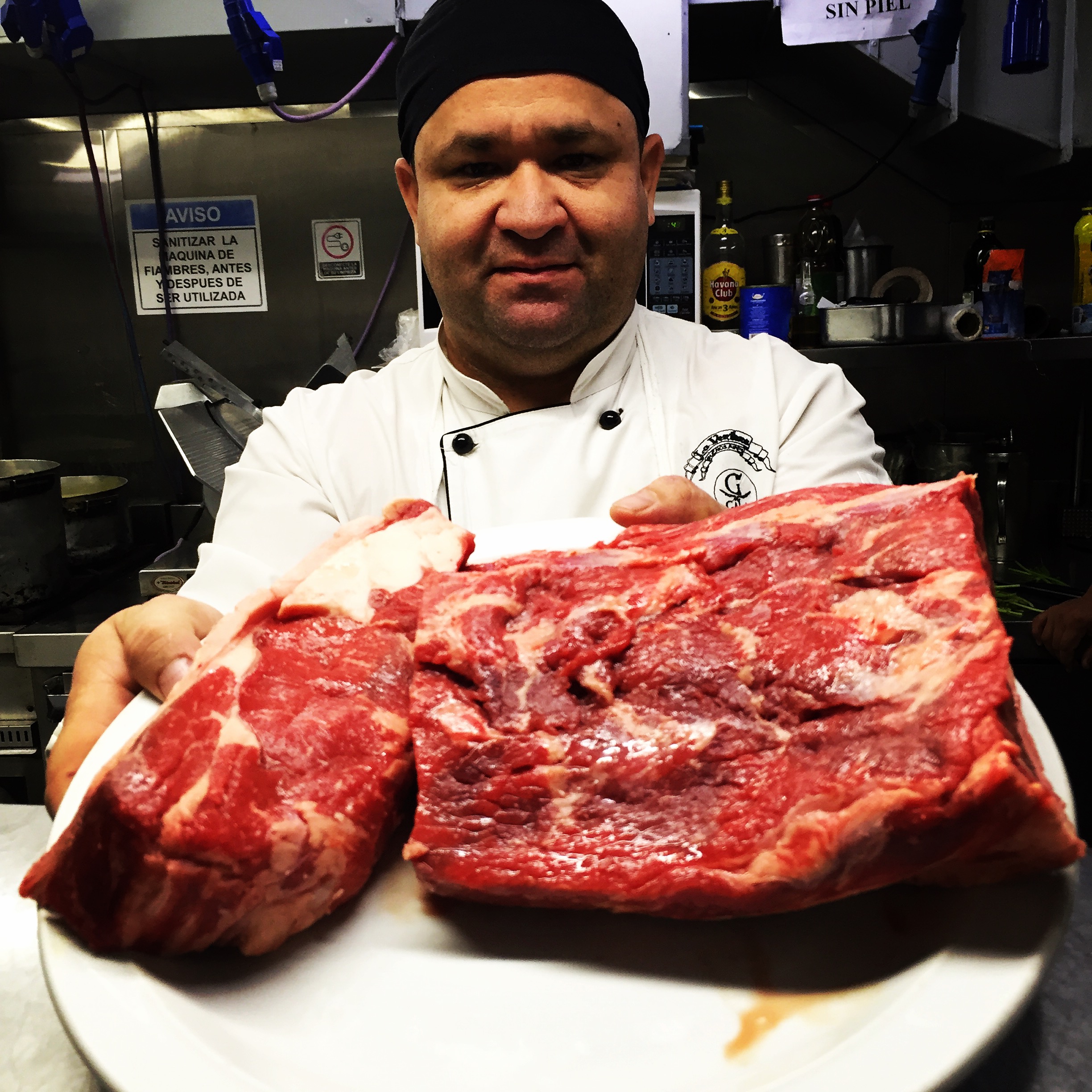 A chef holds up the steak destined for cooking 