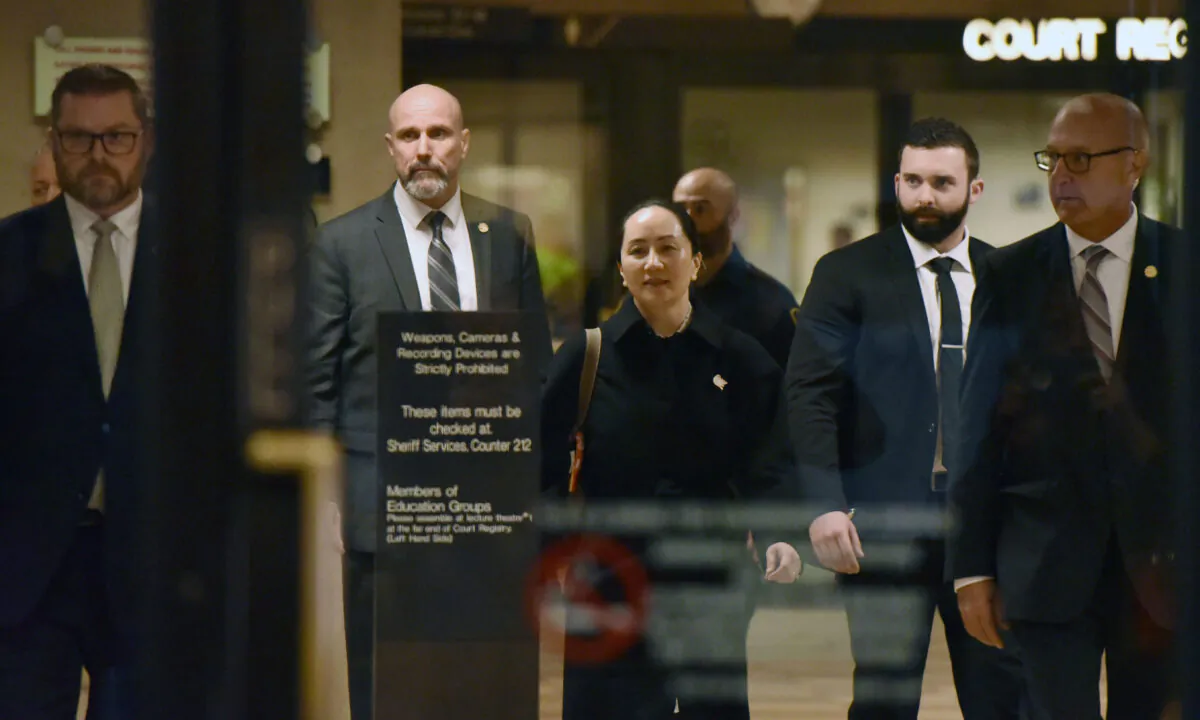 Huawei chief financial officer Meng Wanzhou, after a short morning session that ended the fourth day of trial in her extradition case, leaves British Columbia Supreme Court in Vancouver, Canada, with her security detail on Jan. 23, 2020. (Don Mackinnon/AFP via Getty Images)
