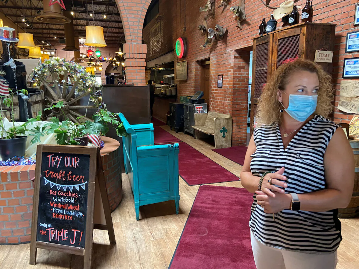 An owner of a restaurant looks out of the establishment's front door, in Lubbock, Texas, June 26, 2020. (Reuters/Brad Brooks)