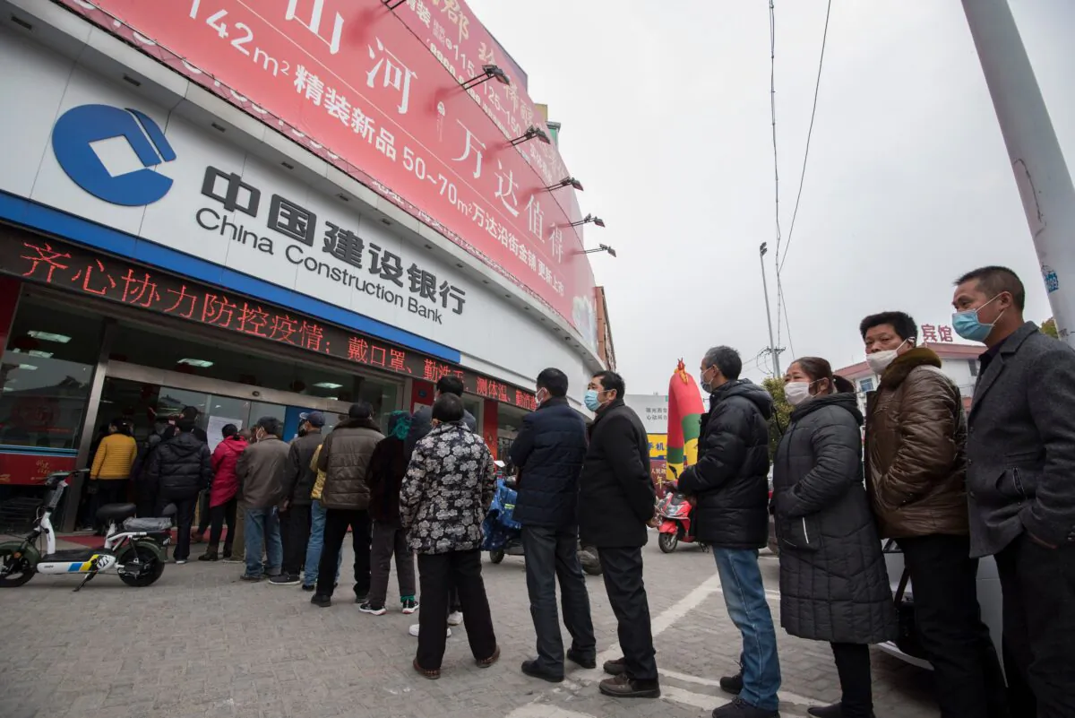 Customers line up to have their temperatures taken before entering a bank in Nantong city, in Jiangsu Province, eastern China, on Feb. 25, 2020. (STR/AFP via Getty Images)