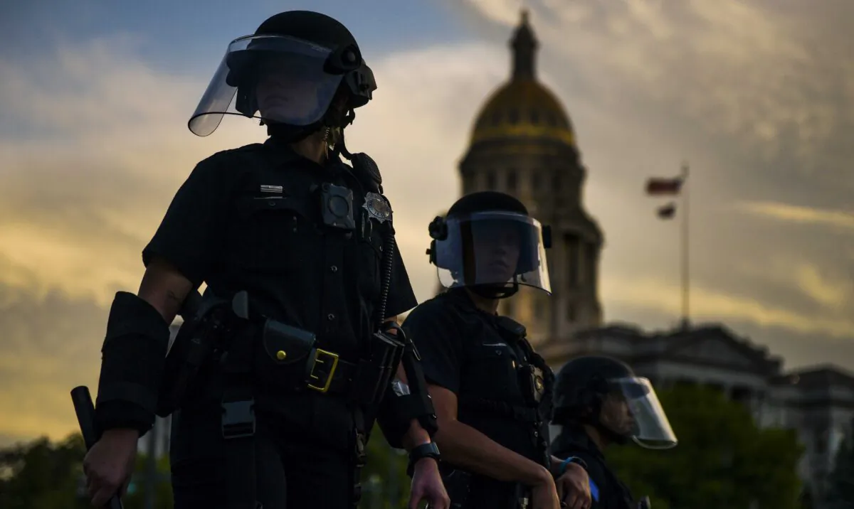 Police officers watch over a crowd of people near the Colorado state capitol during a protest in Denver, Col., on May 29, 2020. (Michael Ciaglo/Getty Images)