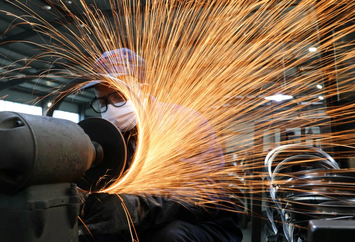 A worker works on a production line manufacturing bicycle steel rim at a factory in Hangzhou, Zhejiang province, China, on March 2, 2020. (China Daily via Reuters)