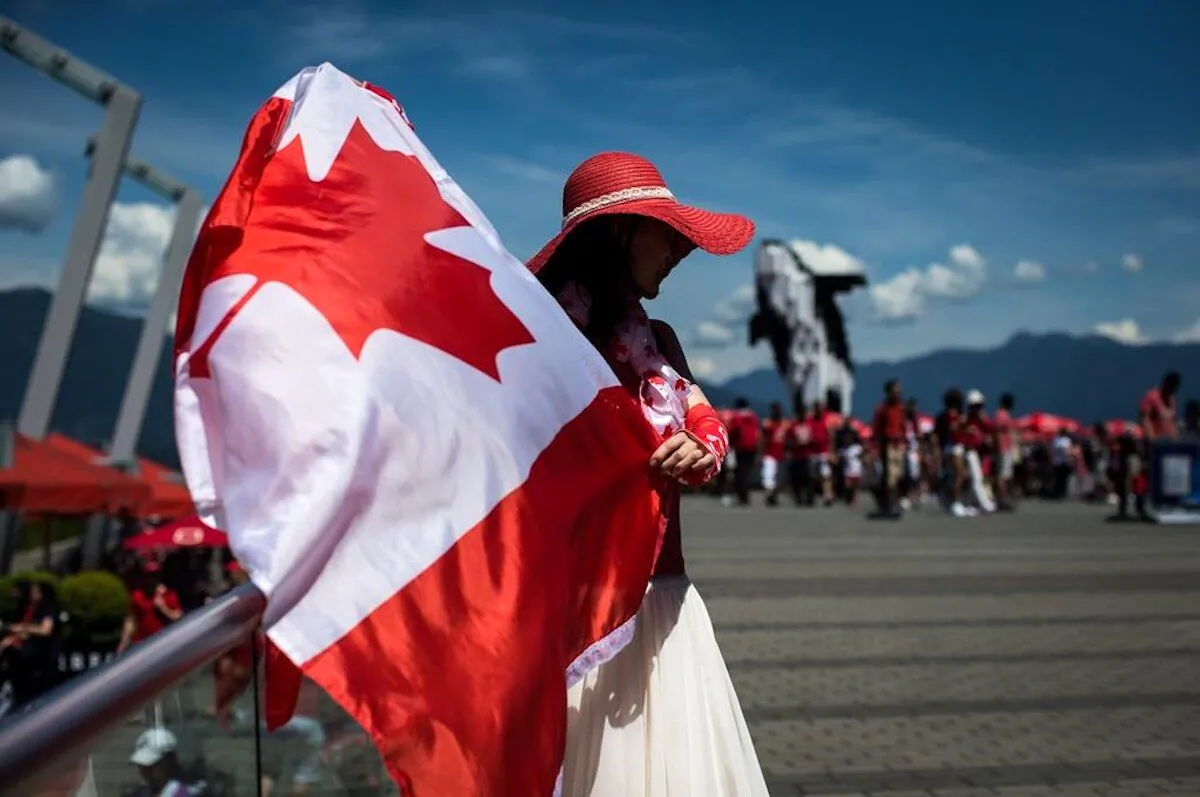 Summer Shen waves a Canadian flag while sporting a patriotic outfit during Canada Day celebrations in Vancouver, on July 1, 2019. (Darryl Dyck/The Canadian Press)