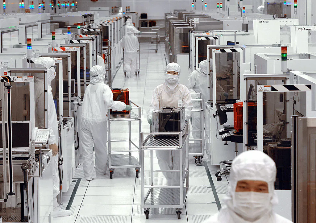 Engineers of United Microelectronics Corp (UMC) push trollies at the 12-inch UMC wafer factory in Tainan Science Park, Taiwan, on April 28, 2006. (Sam Yeh/AFP via Getty Images)