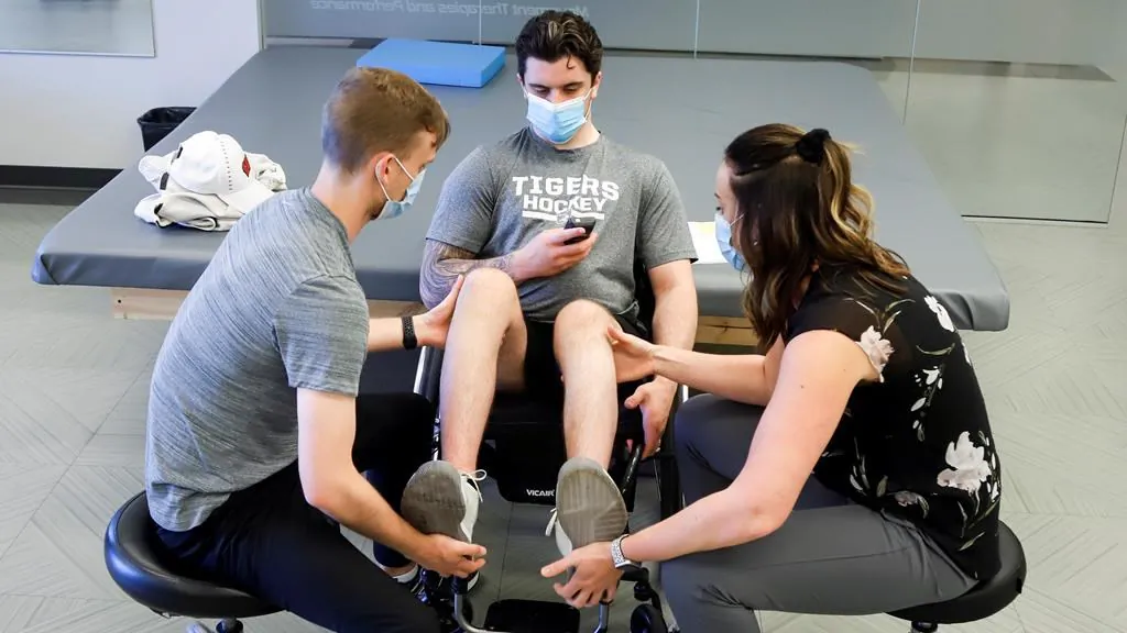 Humboldt Broncos bus crash survivor Ryan Straschnitzki (C) works out with the help of physiotherapists Jill Truman and Matthew Wright, during a training session in Calgary on June 25, 2020. (The Canadian Press/Jeff McIntosh)