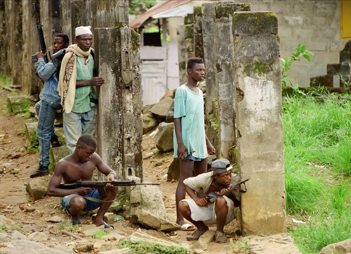 Rebels loyal to Charles Taylor's National Patriotic Front of Liberia wait to ambush members of a rival faction in Monrovia, Liberia, on May 9, 2000. (Christophe Simon/AFP via Getty Images)