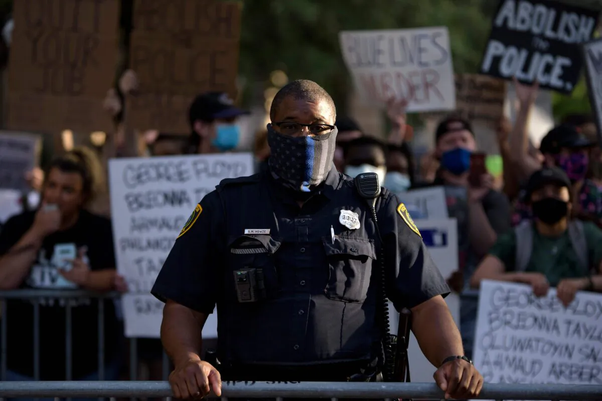 A police officer stands between Police Appreciation rally attendees and counter-protesters at the City Hall in Houston, Texas, on June 18, 2020. (Mark Felix/AFP via Getty Images)
