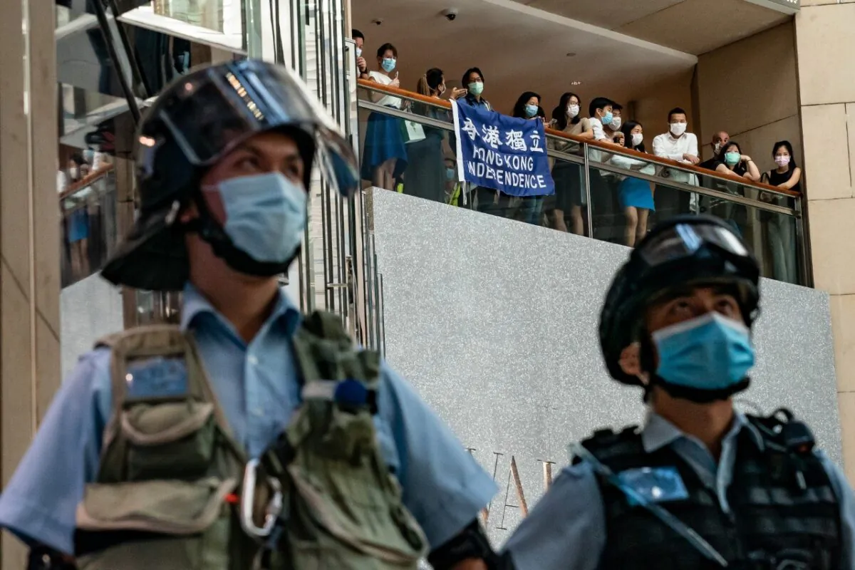 Pro-democracy supporters hold a Hong Kong Independence flag and shout slogans during a rally against the national security law as riot police secure an area in a shopping mall on June 30, 2020 in Hong Kong. Beijing has passed the controversial national security law which will threaten the city's autonomy and political freedoms. ( Anthony Kwan/Getty Images)