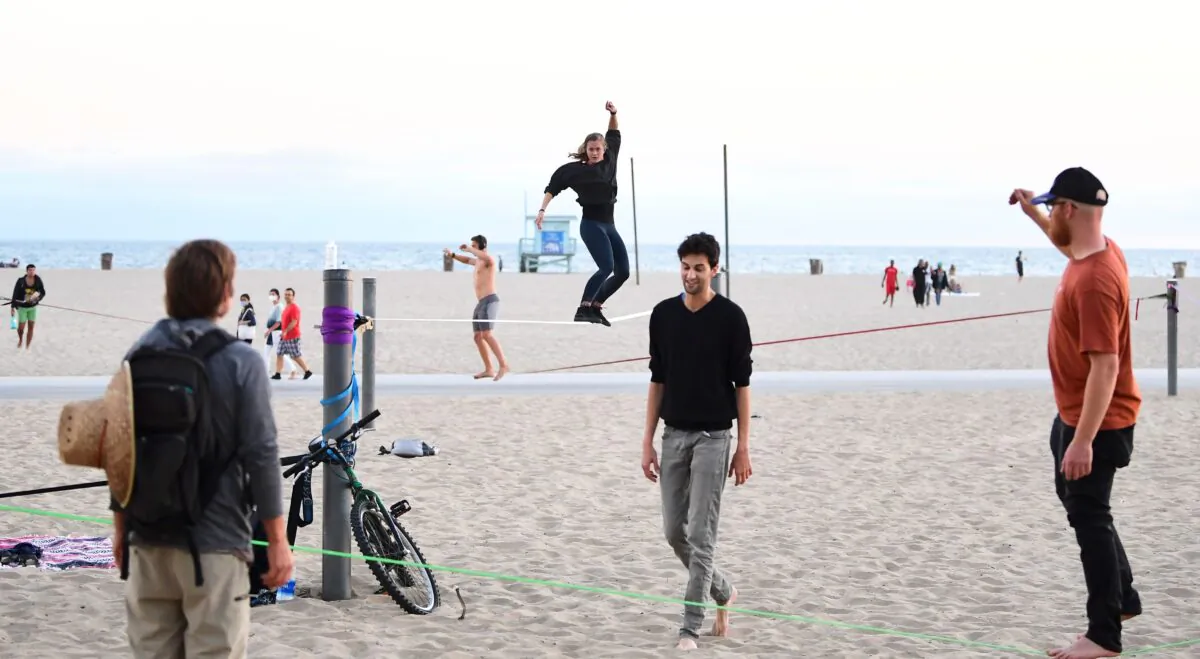 Slackliners practice their rope walking skills at Santa Monica Beach in California on June 25, 2020. (Frederic J. Brown/AFP via Getty Images)