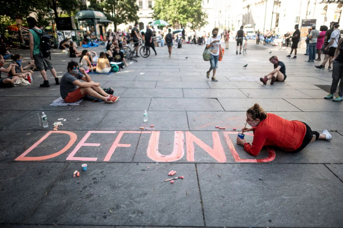 People sit on the ground at a protest to defund the police in an area demonstrators named "City Hall Autonomous Zone" near City Hall in Lower Manhattan in New York City, N.Y., on June 26, 2020. (Johannes Eisele/AFP via Getty Images)