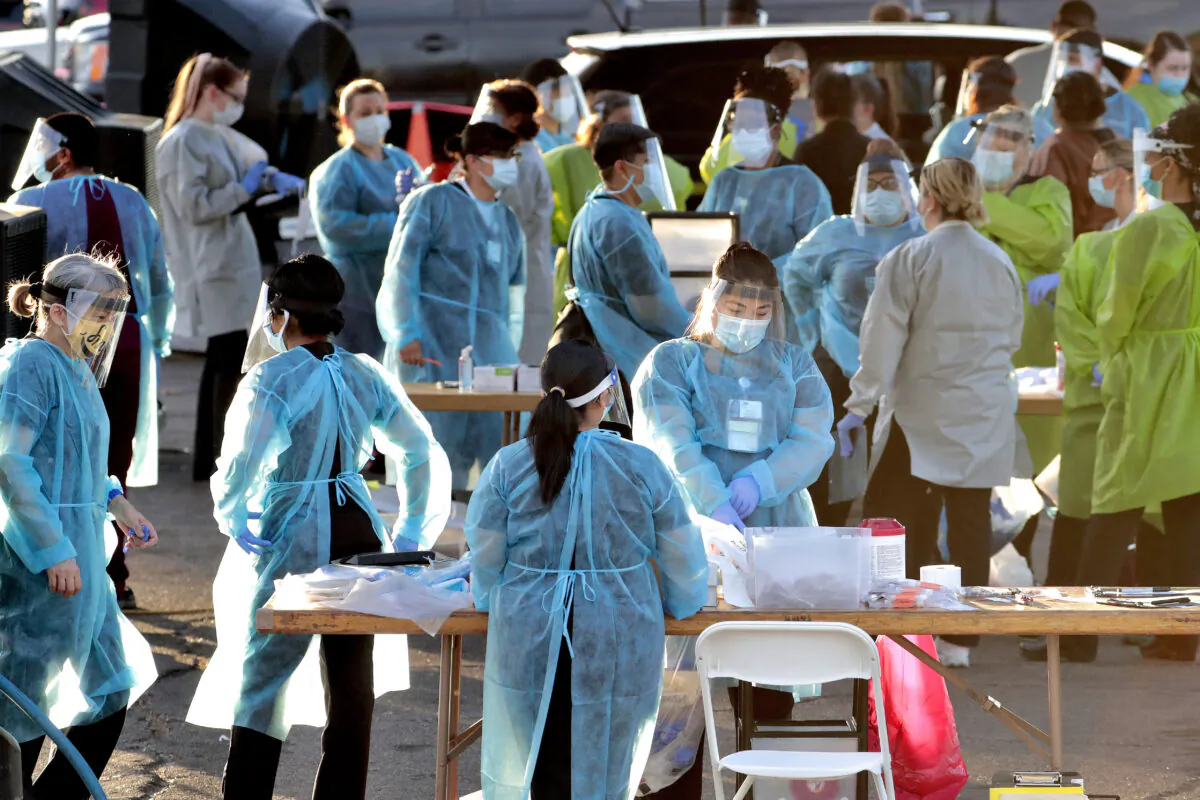 Medical personnel prepare to test hundreds of people lined up in vehicles in Phoenix's western neighborhood of Maryvale in Phoenix for free COVID-19 tests organized by Equality Health Foundation, which focuses on care in underserved communities, in Phoenix, Ariz., on June 27, 2020. (Matt York/AP Photo)