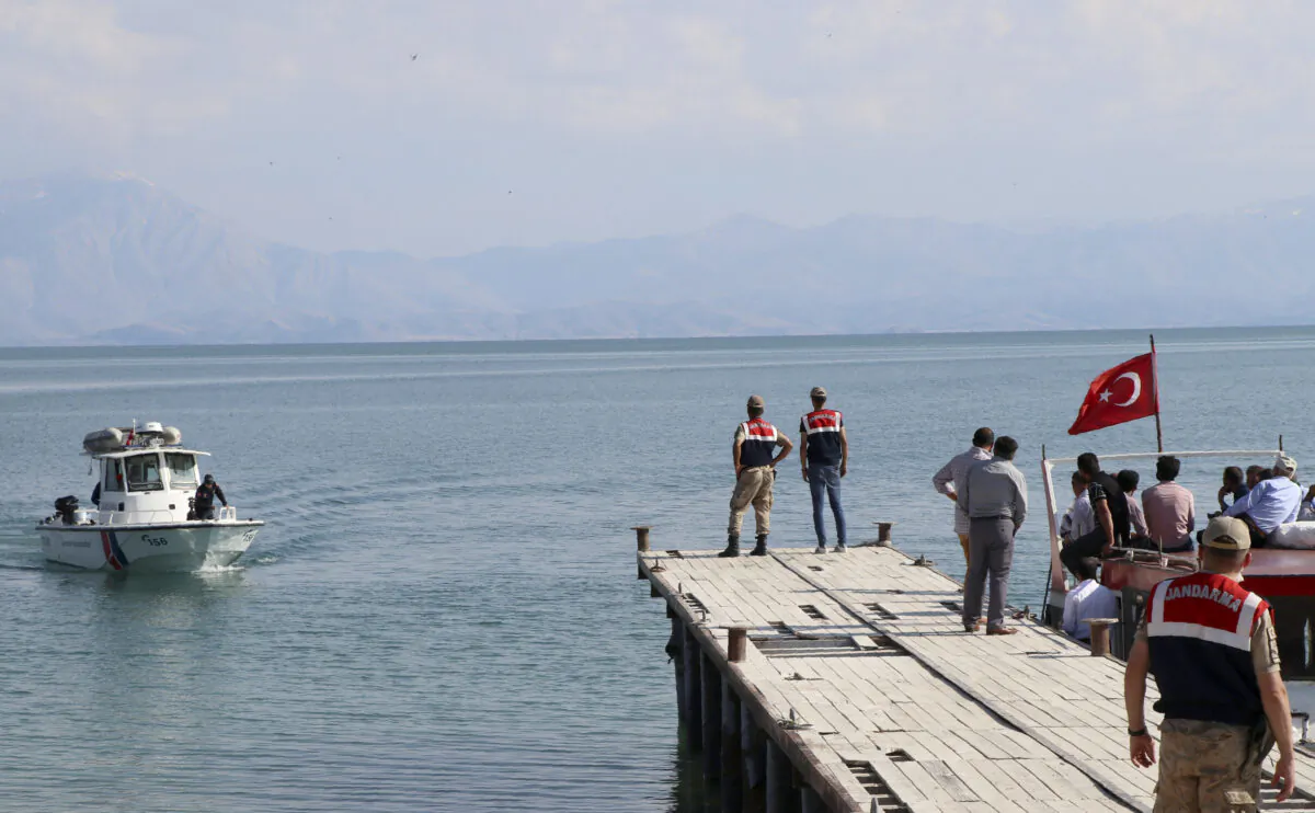 A paramilitary boat searches for people in Lake Van, in eastern Turkey, on July 1, 2020. Up to 60 migrants may have been trapped in a boat that sank in the lake last week, Turkey's Interior Minister Suleyman Soylu said. (DHA via AP)