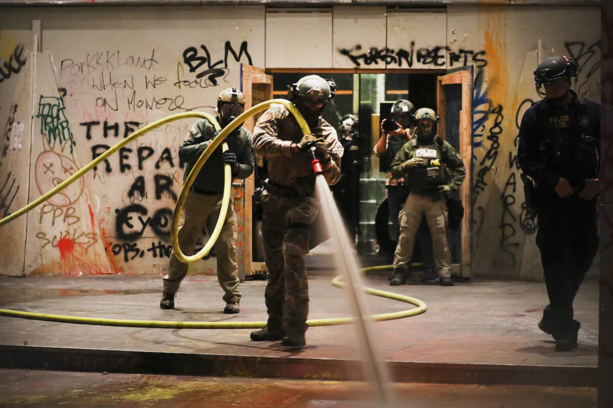 Federal police clean in front of the Mark O. Hatfield federal courthouse in downtown Portland in Portland, Oregon, on July 28, 2020. (Spencer Platt/Getty Images)