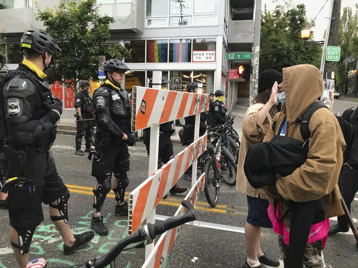 Occupiers of the so-called CHOP on the right and Seattle police officers on the left as police clear the area on July 1, 2020. (Aron Ranen/AP Photo)