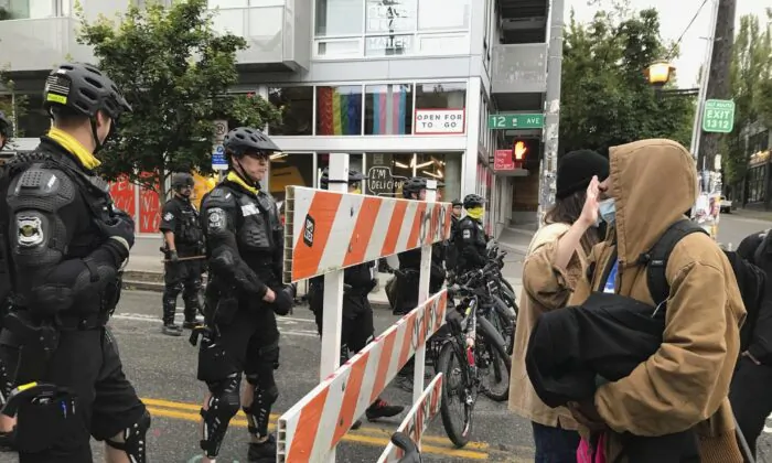 Occupiers of the so-called CHOP on the right and Seattle police officers on the left as police clear the area on July 1, 2020. (Aron Ranen/AP Photo)