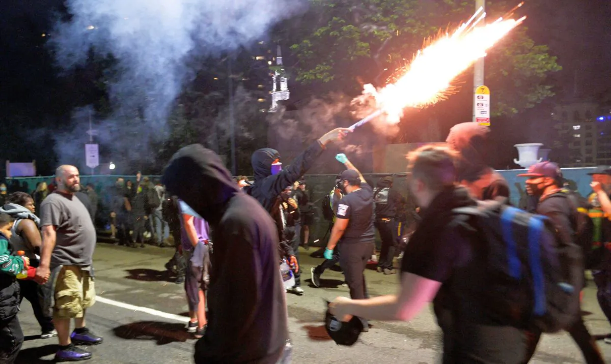 A protester fires fireworks at the police by the steps the State House during protest against the death of George Floyd, in Boston, Mass., on June 2, 2020. (Joseph Prezioso/AFP via Getty Images)