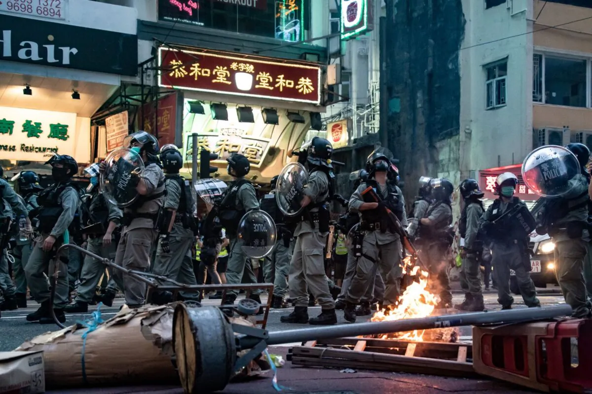 HONG KONG, CHINA - JULY 01: Riot police secure an area in front of a burning road block during a demonstration against the new national security law on July 1, 2020 in Hong Kong, China. Hong Kong marks the 23rd anniversary of its handover to China on July 1 after Beijing imposed the new national security law. (Photo by Anthony Kwan/Getty Images)