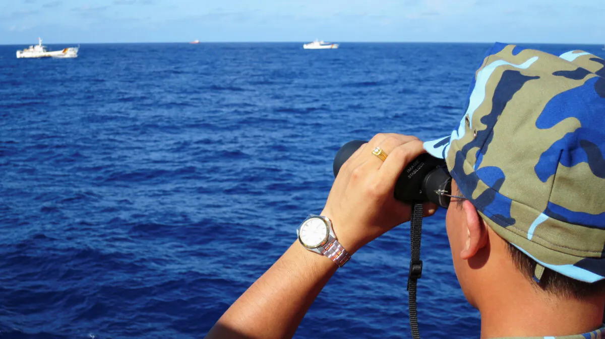 A crewman from a Vietnamese coastguard ship looks out at sea as Chinese coastguard vessels give chase to Vietnamese ships in the South China Sea, on July 15, 2014. (Martin Petty/Reuters)