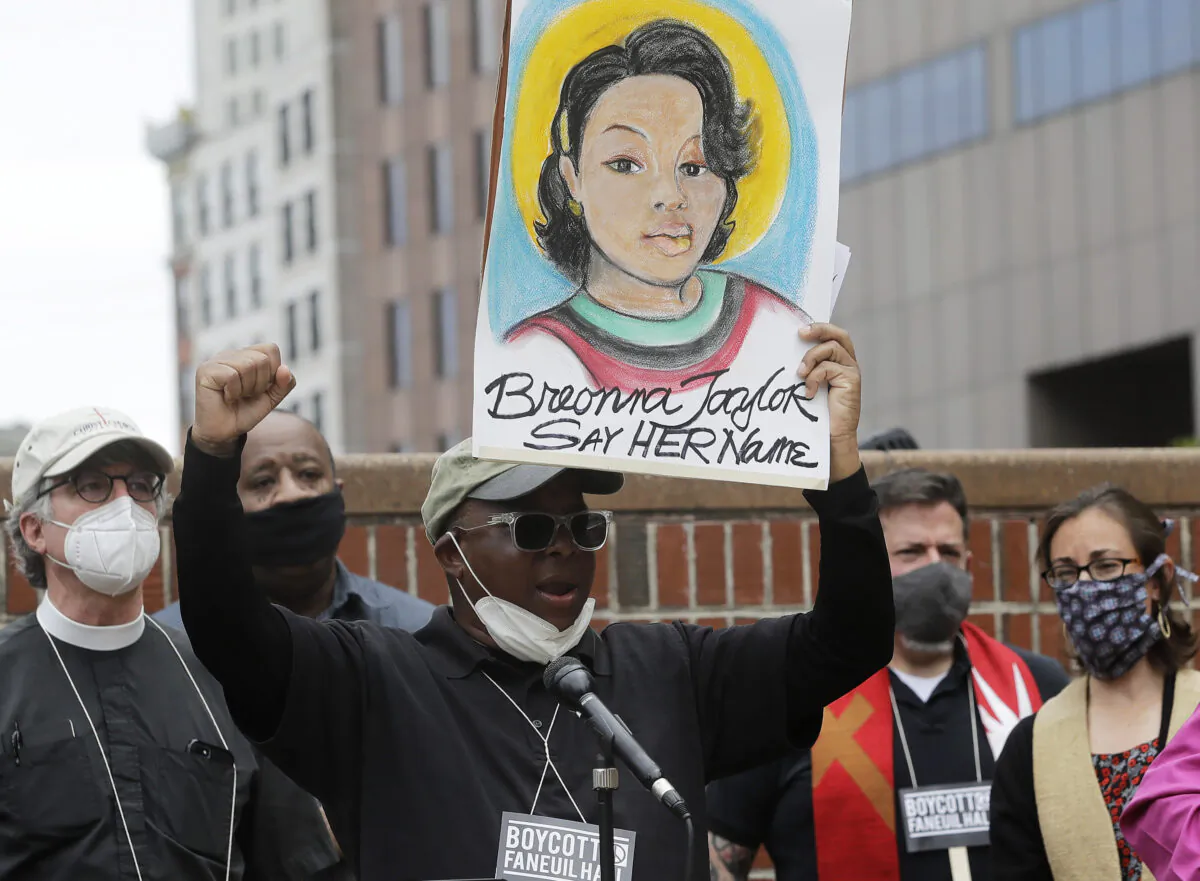 Kevin Peterson, center, founder and executive director of the New Democracy Coalition, displays a placard showing Breonna Taylor as he addresses a rally in Boston, on June 9, 2020. (Steven Senne/AP Photo)