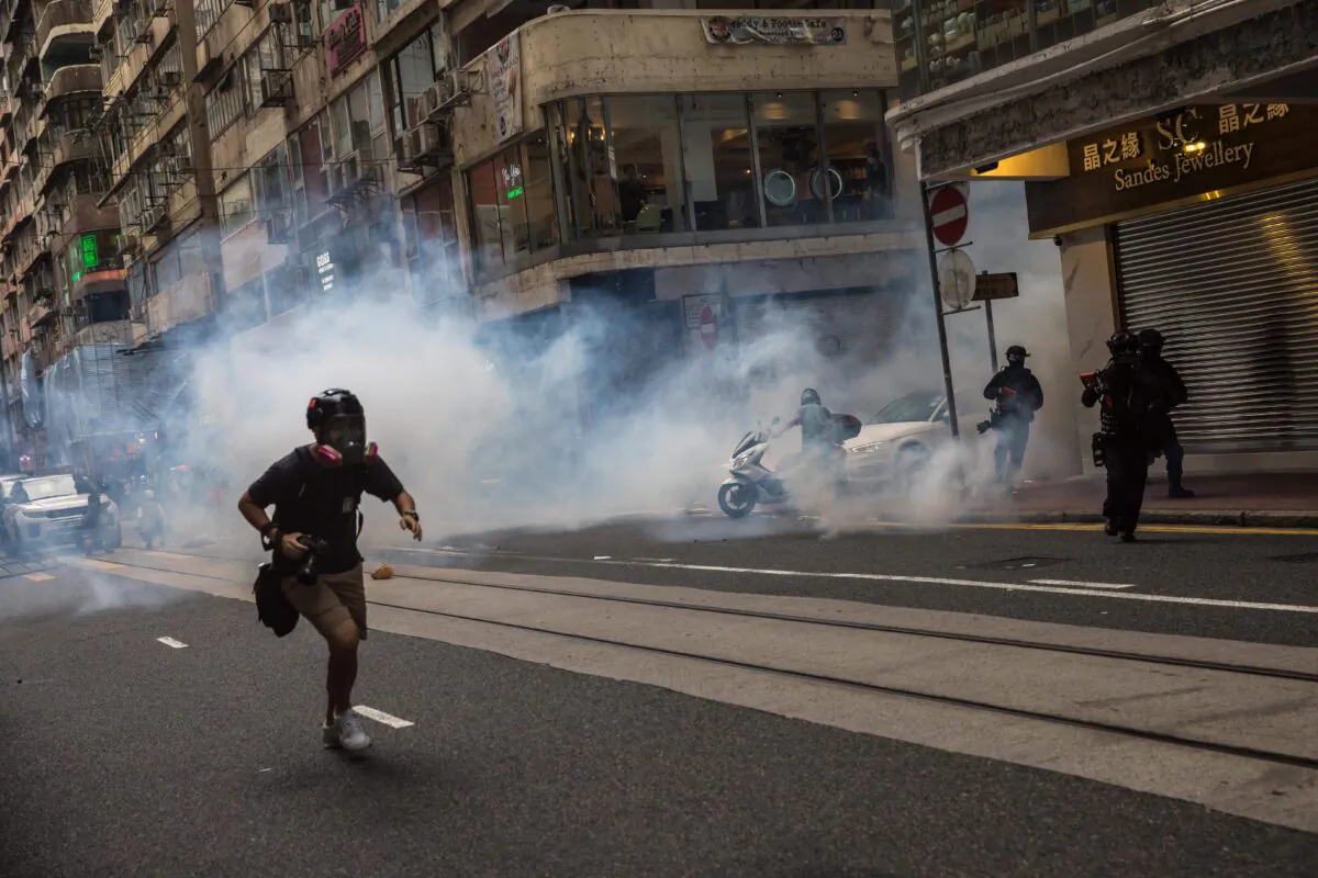 Riot police deploy tear gas as they clear protesters from a road during a rally against a new national security law in Hong Kong on July 1, 2020, on the 23rd anniversary of the city's handover from Britain to China. (Dale de la Rey/AFP via Getty Images)
