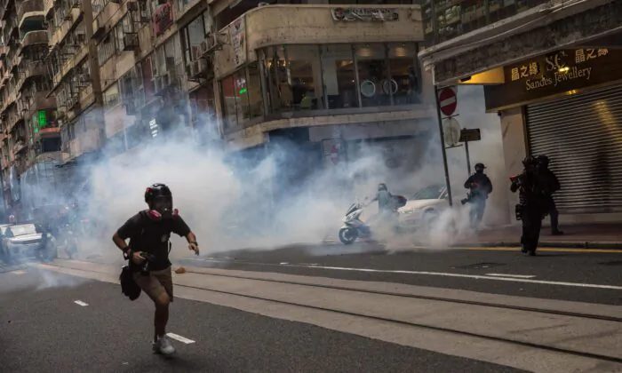 Riot police deploy tear gas as they clear protesters from a road during a rally against a new national security law in Hong Kong on July 1, 2020, on the 23rd anniversary of the city's handover from Britain to China. (Dale de la Rey/AFP via Getty Images)