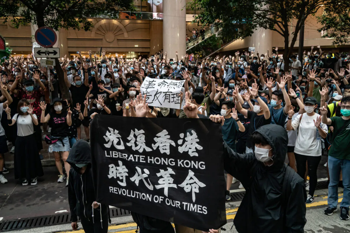 Riot police detain a man as they raise a warning flag during a demonstration against the new national security law in Hong Kong, on July 1, 2020. (Anthony Kwan/Getty Images)