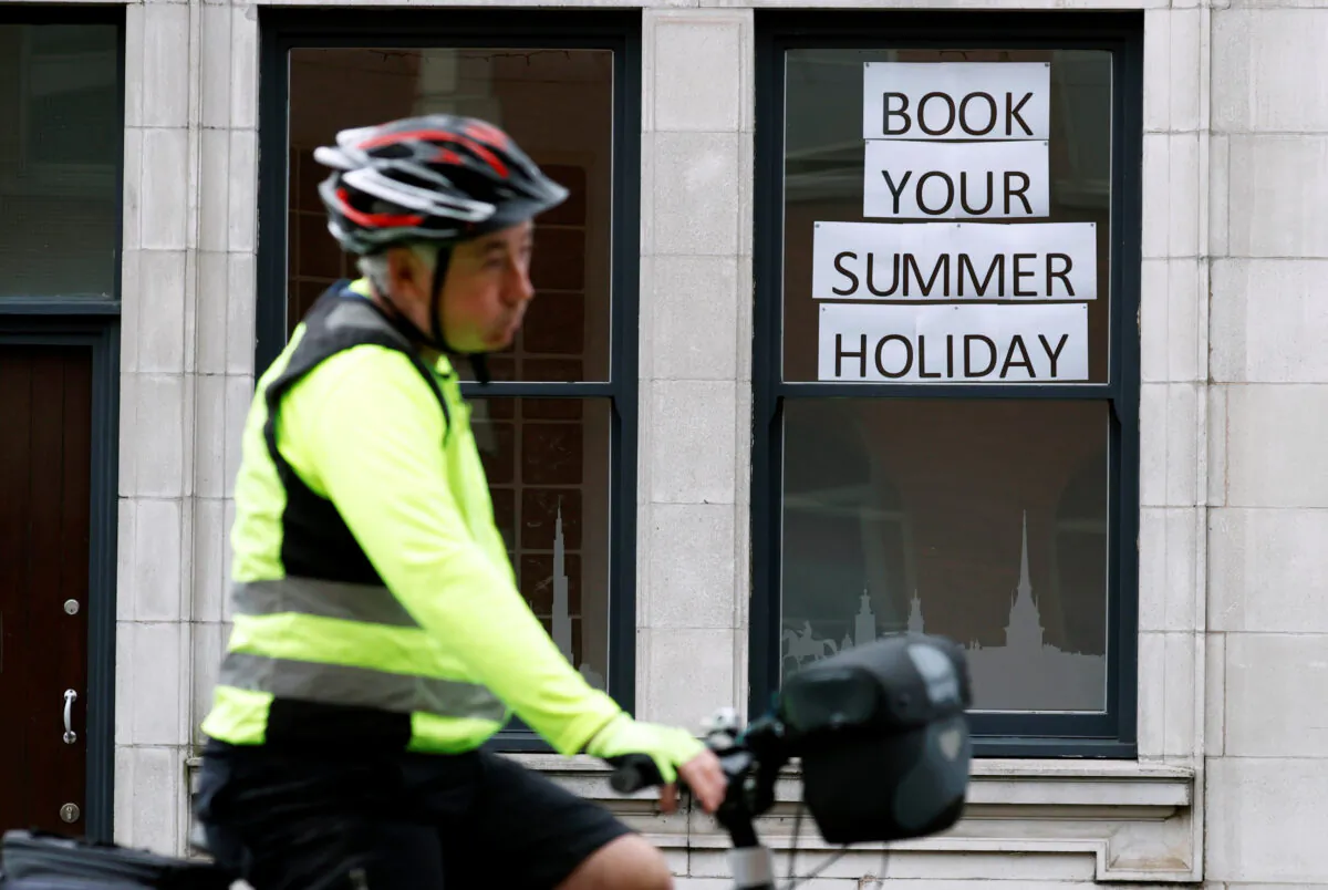 A man rides a bicycle past a travel agents store, amid the coronavirus disease (COVID-19) outbreak, in Manchester, England, on July 2, 2020. (Phil Noble/Reuters)