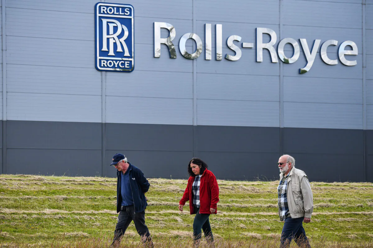 People walk past the Rolls Royce Inchinan factory on June 11, 2020, in Inchinnan, Scotland. Jet engine manufacturer Rolls-Royce is expected to cut 20 percent of its workforce, including 700 jobs at the Inchinnan plant, following a sharp decline in business as a result of the coronavirus outbreak. (Jeff J Mitchell/Getty Images)