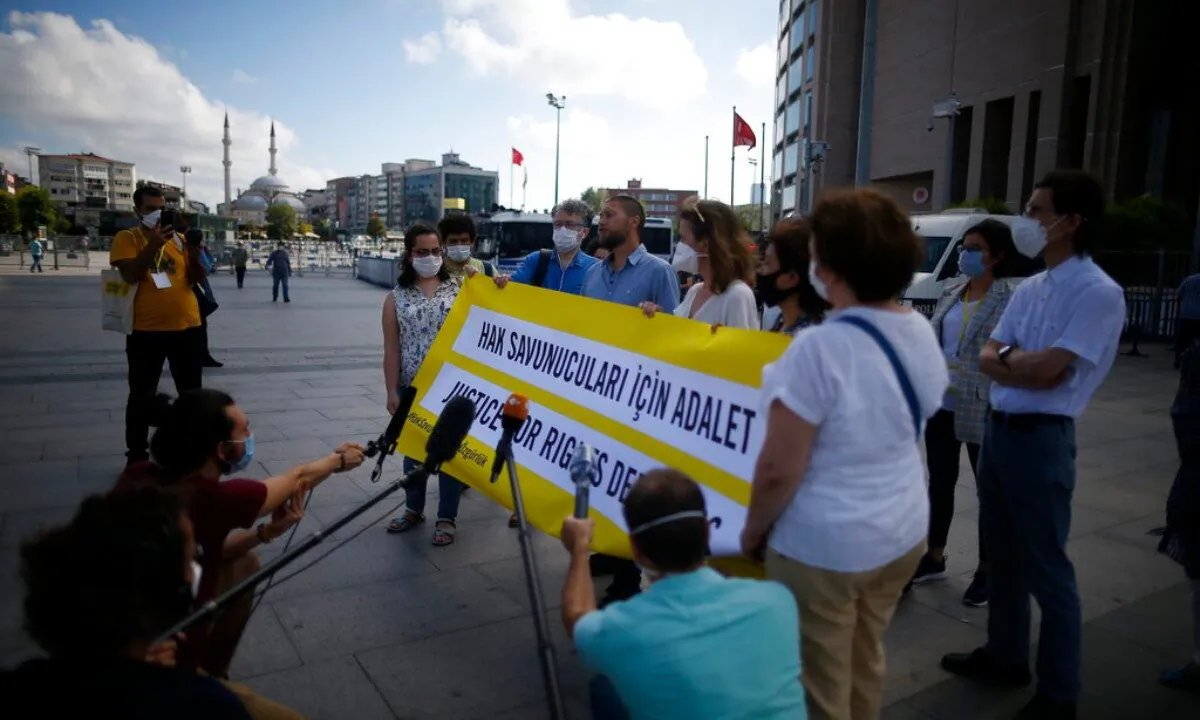 Protesters from Amnesty International talk to the media as they stage a protest outside a court in Istanbul, on July 3, 2020, where the trial of 11 prominent human rights activists for terror-related charges and adjourned proceedings continued. (Emrah Gurel/AP Photo)