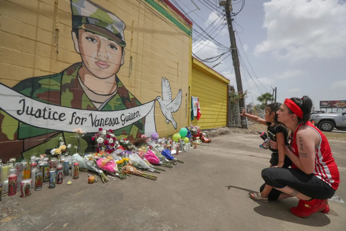 Dawn Gomez holds her 3-year-old granddaughter, Saryia Greer, who waves at Vanessa Guillen's mural painted by Alejandro "Donkeeboy" Roman Jr. on the side of Taqueria Del Sol, in Houston, on July 2, 2020. (Steve Gonzales/Houston Chronicle/AP)
