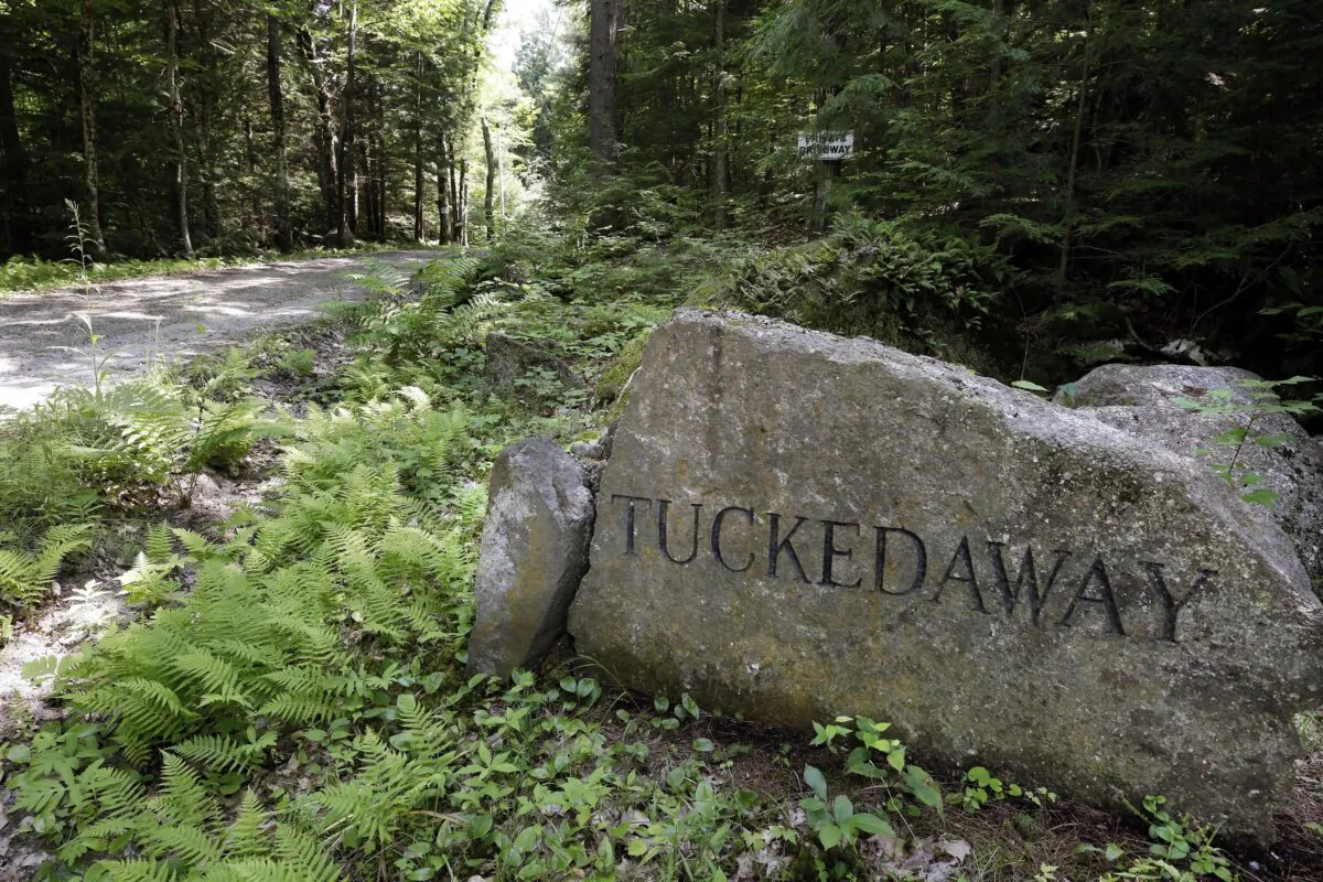 A boulder inscribed with "Tucked Away" sits beside a road going to an estate where Ghislaine Maxwell was taken into custody, in Bradford, N.H., on July 2, 2020. (Steven Senne/AP Photo)