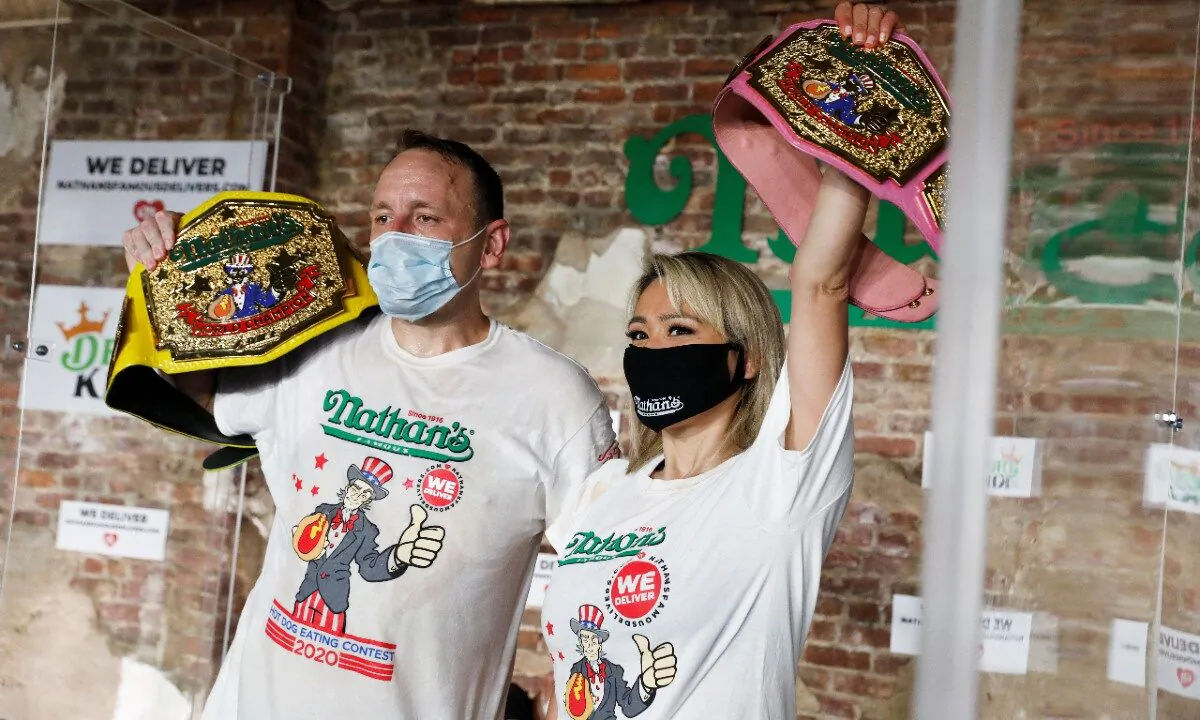 Men's champion Joey Chestnut and women's champion Miki Sudo pose together after winning the Nathan's Famous Fourth of July International Hot Dog Eating Contest in Brooklyn, in New York City, July 4, 2020. (Andrew Kelly/Reuters)