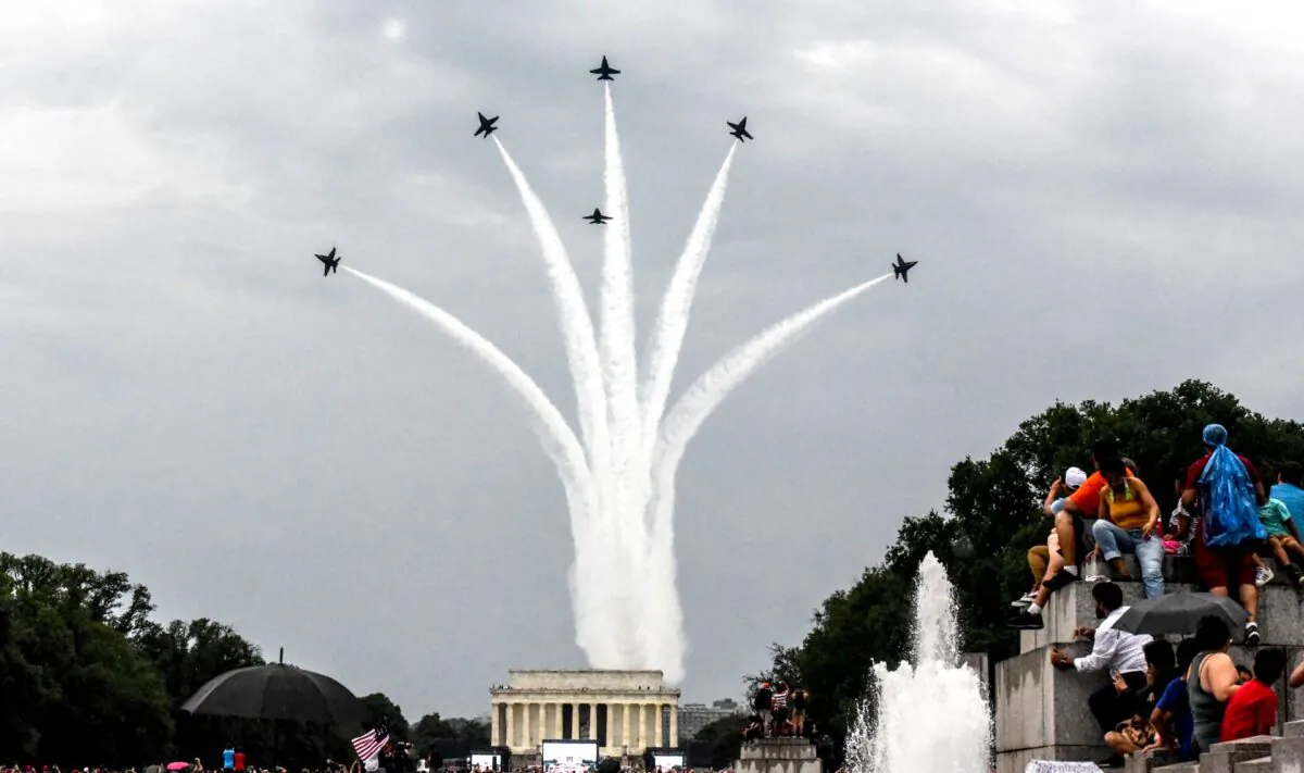 People react to a military fly over on the National Mall while President Donald Trump gives his speech during Fourth of July festivities in Washington, on July 4, 2019. (Stephanie Keith/Getty Images)