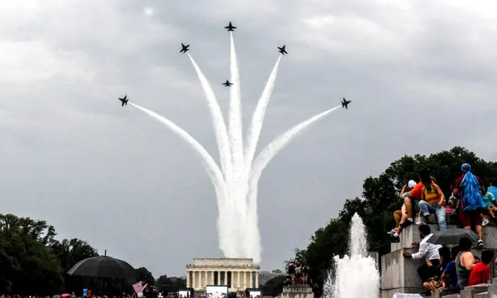 People react to a military fly over on the National Mall while President Donald Trump gives his speech during Fourth of July festivities in Washington, on July 4, 2019. (Stephanie Keith/Getty Images)