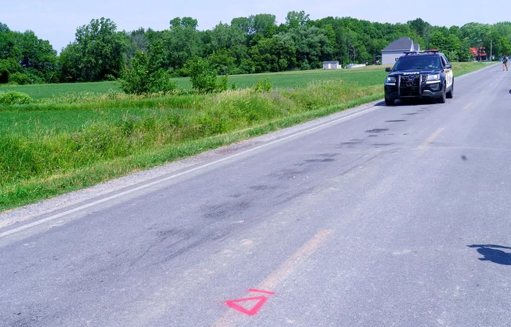 A police car drives along le Rang Sainte-Anne in Notre-Dame-de-Stanbridge, Que. on July 2, 2020, where three children aged five and under died following a tractor accident Wednesday evening. (Paul Chiasson/The Canadian Press)