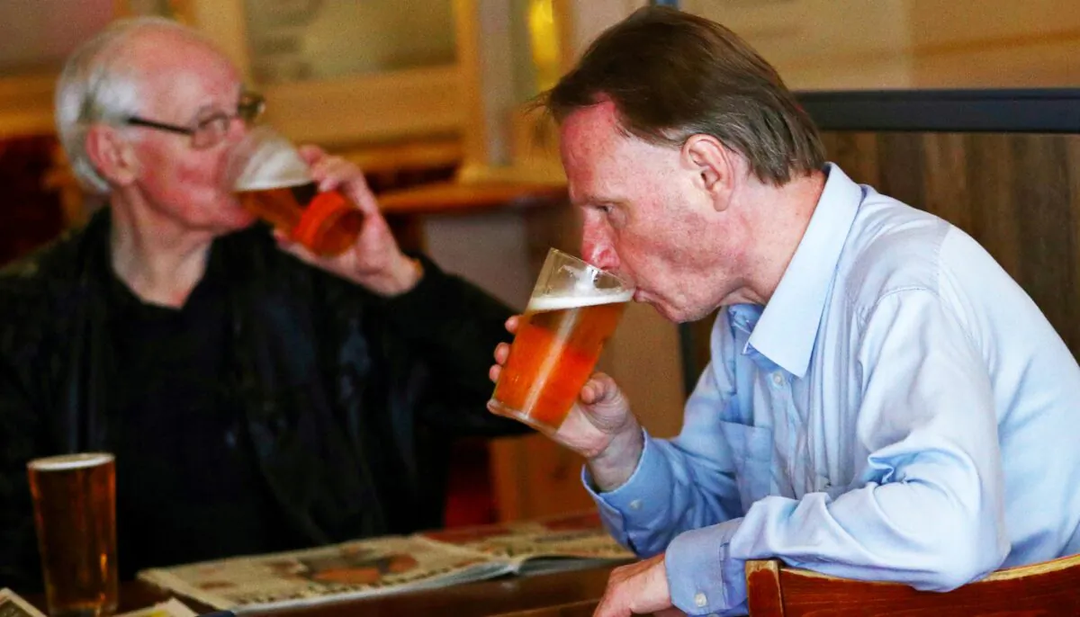 Customers drink beer at The Holland Tringham Wetherspoons pub after it reopened following the outbreak of COVID-19, in London, on July 4, 2020. (Hannah McKay/Reuters)