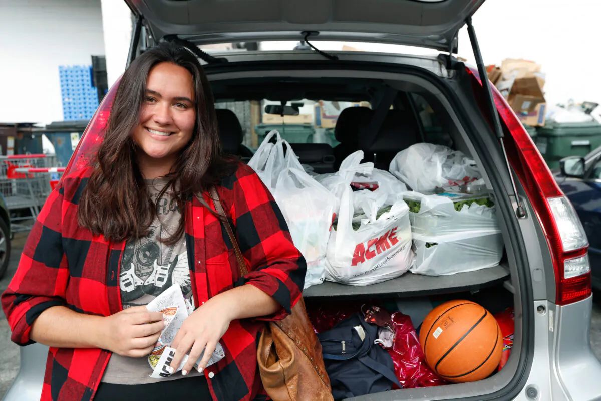 Alexandra Lopez-Djurovic poses for a photograph in the parking lot of an Acme supermarket after shopping for a client, in Bronxville, N.Y., on July 1, 2020. Ms. Lopez-Djurovic was working full time as a nanny until her hours were cut substantially due to the coronavirus pandemic, so she started her own grocery delivery service that made up for some of her lost wages but not all. (Kathy Willens/AP Photo)
