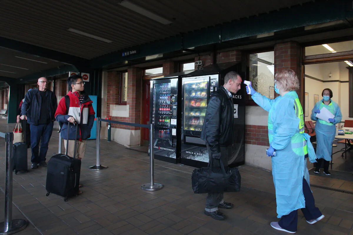 A nurse takes the temperature of an arriving rail passenger from Melbourne at Central Station in Sydney, Australia on July 3, 2020. (Lisa Maree Williams/Getty Images)