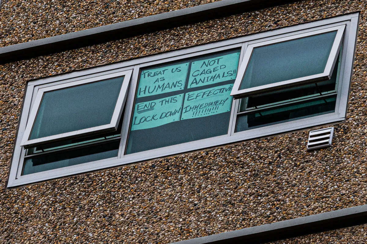 A sign is seen stuck to a window reading 'Treat us as humans not caged animals end this lockdown effective immediately' at the Flemington Public housing flats in Melbourne, Australia, on July 5, 2020. (Asanka Ratnayake/Getty Images)