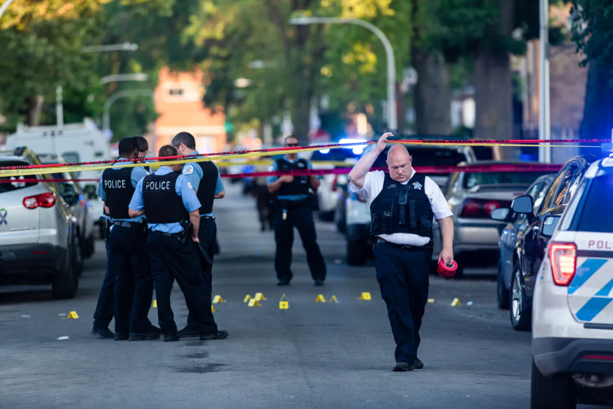 Chicago police officers investigate the scene of a deadly shooting in Chicago, Ill., on July 5, 2020. (Tyler LaRiviere/Chicago Sun-Times via AP)