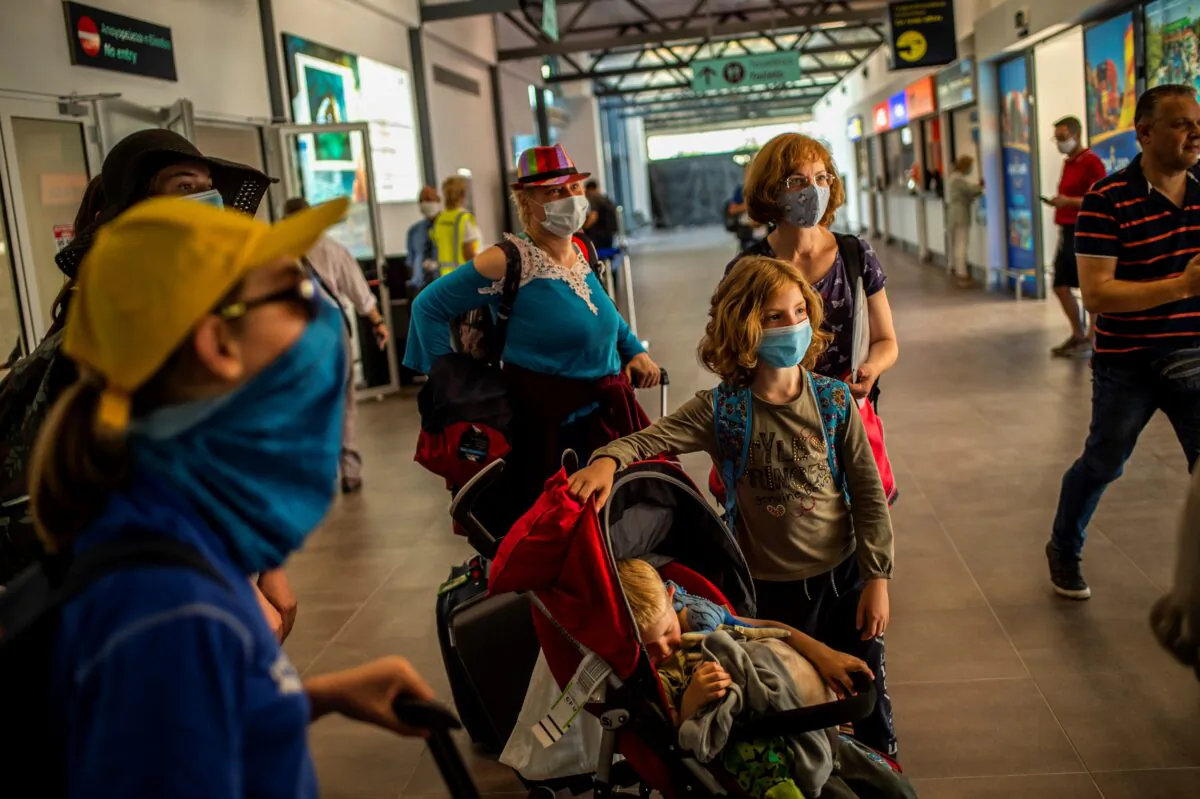 Passengers of a flight from Budapest wearing protective face masks arrive at the Corfu Airport Ioannis Kapodistrias on Corfu Island on July 1, 2020. (Angelos Tzortzinis /AFP via Getty Images)