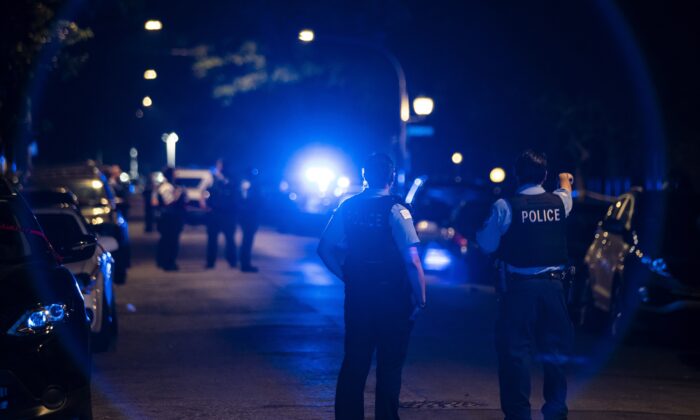 Chicago police officers investigate the scene of a shooting in Chicago on July 5, 2020. (Ashlee Rezin Garcia/Chicago Sun-Times via AP)