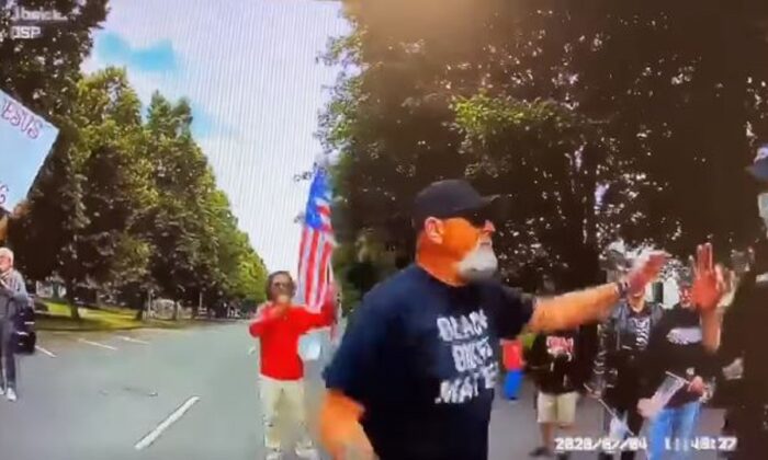 An Oregon State Police officer, right, makes an "ok" hand signal while speaking to a man at a protest in Salem, Ore., on July 4, 2020. (Oregon State Police)