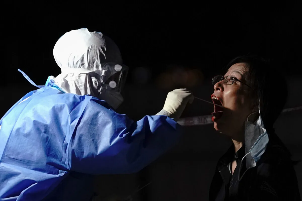 A medical worker takes a swab sample at a test station in Beijing on July 6, 2020. (Lintao Zhang/Getty Images)
