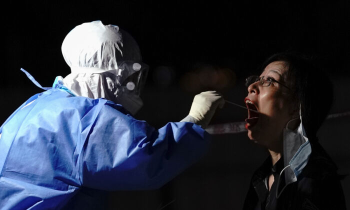 A medical worker takes a swab sample at a test station in Beijing on July 6, 2020. (Lintao Zhang/Getty Images)