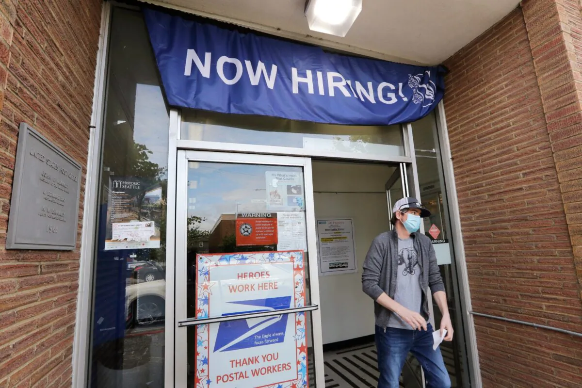 A customer walks out of a U.S. Post Office branch and under a banner advertising a job opening, in Seattle, Wash., on June 4, 2020. (Elaine Thompson/File/AP Photo/)