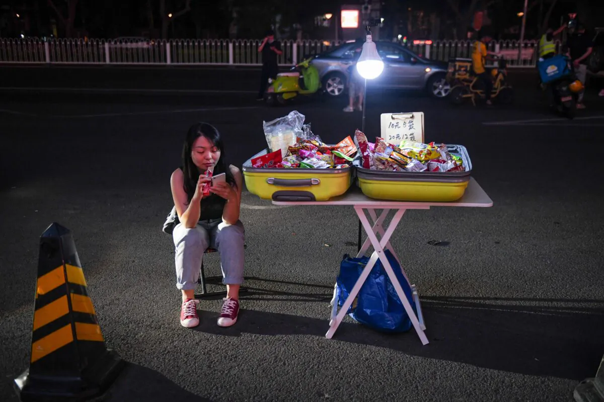 A street vendor waits for customers on the roadside outside a shopping mall in Beijing on June 10, 2020. (GREG BAKER/AFP via Getty Images)