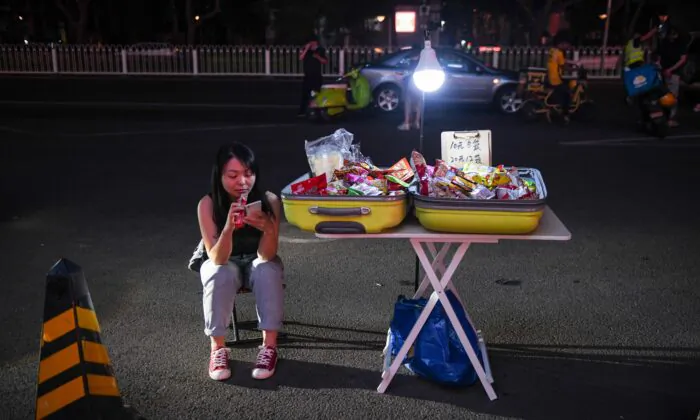 A street vendor waits for customers on the roadside outside a shopping mall in Beijing on June 10, 2020. (GREG BAKER/AFP via Getty Images)